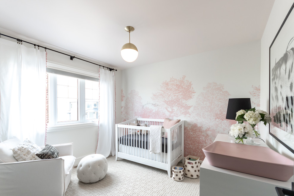 This is an example of a transitional nursery for girls in Other with pink walls, carpet and white floor.