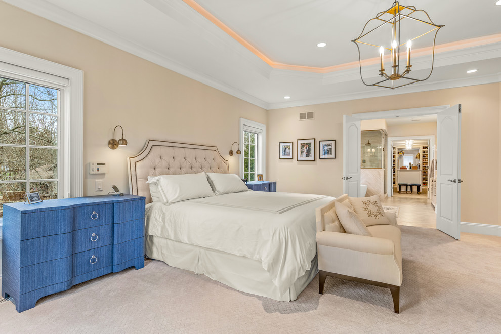Photo of an expansive traditional master bedroom in Cleveland with beige walls, carpet, no fireplace and beige floor.