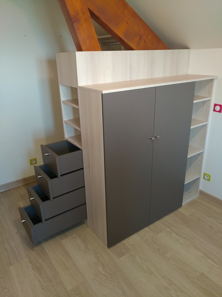 Photo of a small gender-neutral walk-in wardrobe in Other with flat-panel cabinets, beige cabinets, laminate floors and grey floor.