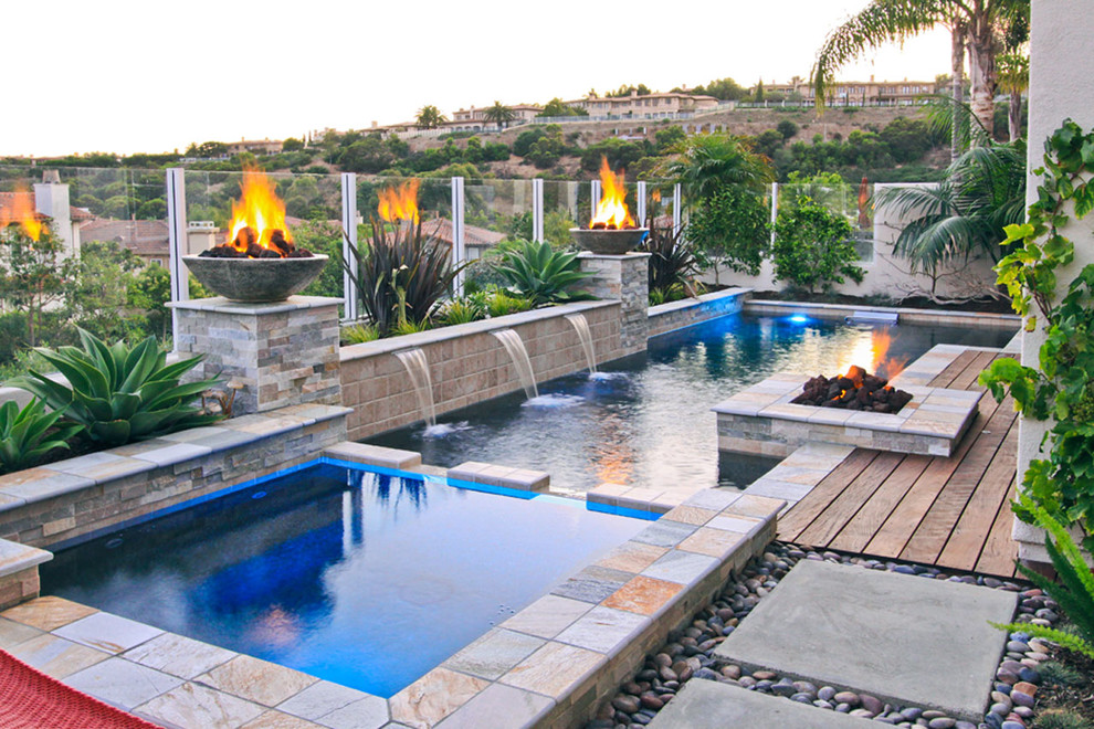 Design ideas for a large contemporary backyard l-shaped natural pool in Orange County with a hot tub and natural stone pavers.