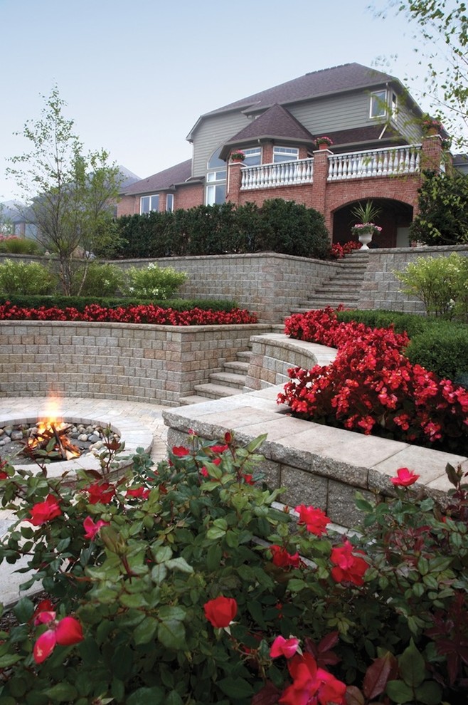 This is an example of a large traditional backyard garden in Toronto with a fire feature and brick pavers.