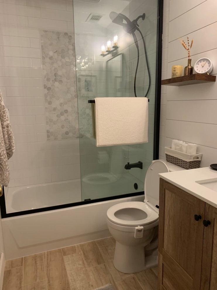Photo of a medium sized rural shower room bathroom with flat-panel cabinets, brown cabinets, a freestanding bath, a shower/bath combination, a one-piece toilet, white tiles, ceramic tiles, white walls, ceramic flooring, a submerged sink, engineered stone worktops, beige floors, a sliding door, white worktops, a single sink, a freestanding vanity unit and tongue and groove walls.