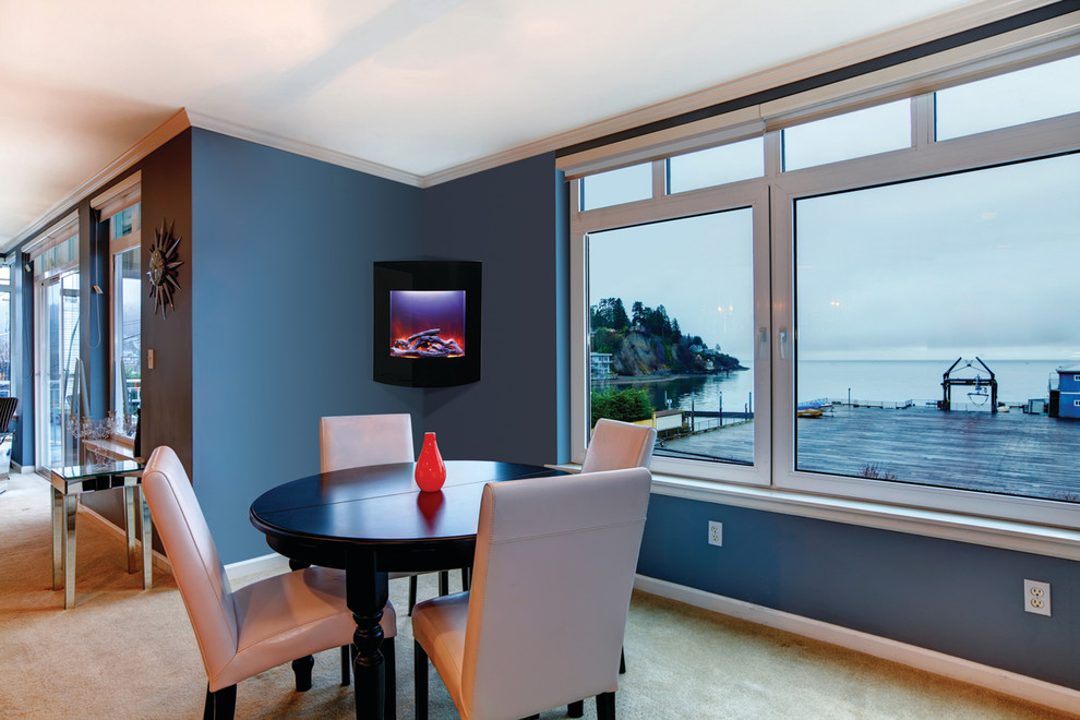 This is an example of a small contemporary open plan dining in Boston with blue walls, carpet and a corner fireplace.
