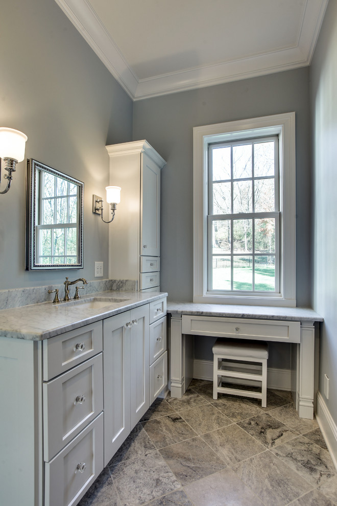 Design ideas for a large transitional master bathroom in Chicago with recessed-panel cabinets, grey cabinets, a two-piece toilet, gray tile, white tile, stone slab, grey walls, ceramic floors, an undermount sink, marble benchtops and brown floor.