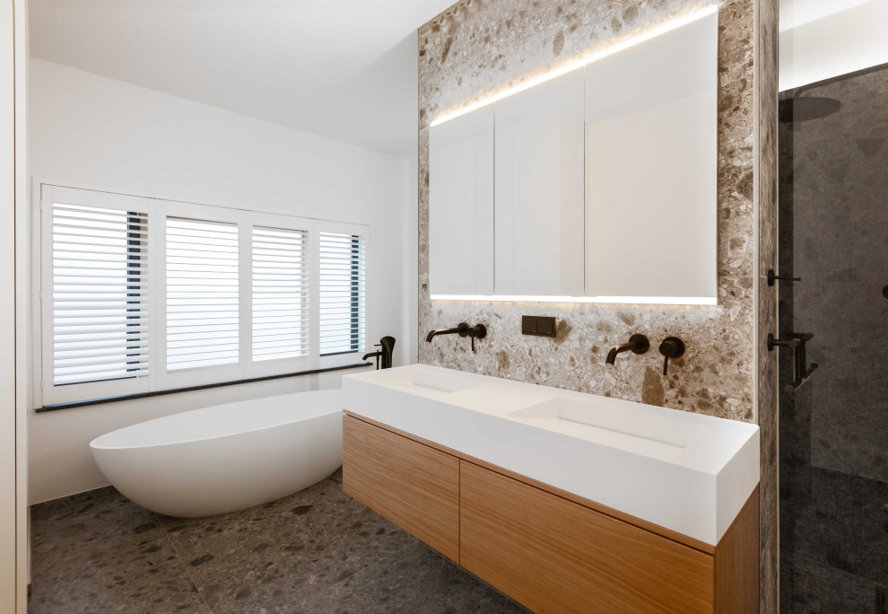 Photo of a contemporary shower room bathroom in Cologne with flat-panel cabinets, light wood cabinets, a freestanding bath, a built-in shower, a wall mounted toilet, grey tiles, stone tiles, white walls, cement flooring, a vessel sink, wooden worktops, grey floors, an open shower, an enclosed toilet, double sinks, a floating vanity unit, a wallpapered ceiling and wallpapered walls.
