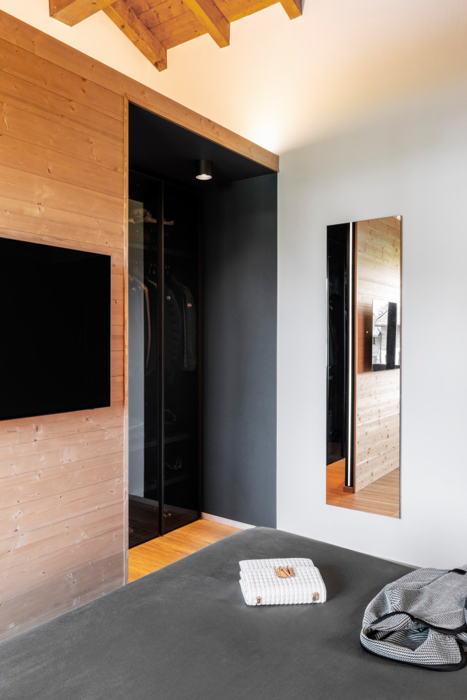Kleines Rustikales Schlafzimmer mit grauer Wandfarbe, Laminat, braunem Boden, Holzdecke und Holzwänden in Mailand