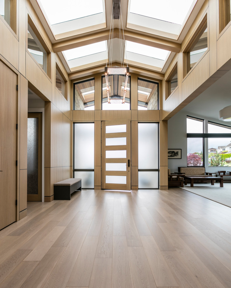 Großes Klassisches Foyer mit hellem Holzboden, Einzeltür, heller Holzhaustür, gewölbter Decke und Holzwänden in Seattle