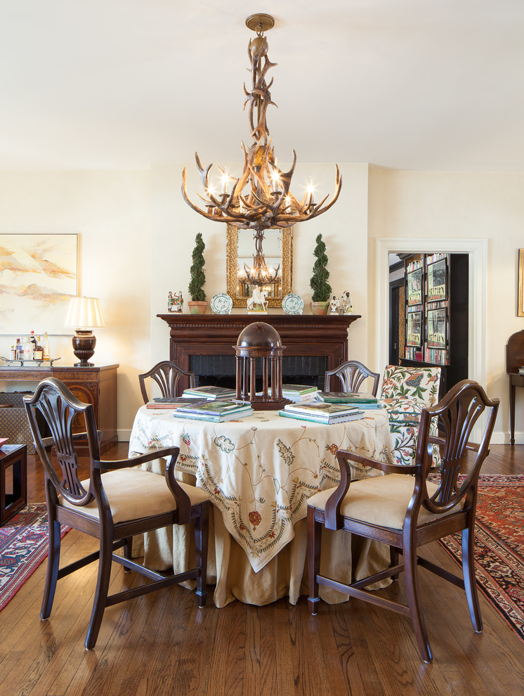 Photo of a traditional dining room in Chicago with beige walls, dark hardwood floors and a brick fireplace surround.