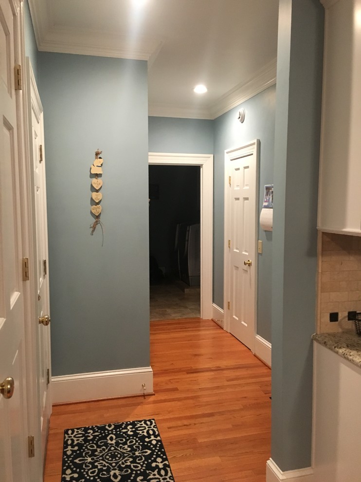 Inspiration for a mid-sized transitional medium tone wood floor and brown floor hallway remodel with blue walls