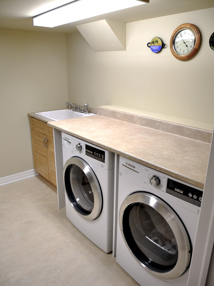 Inspiration for a mid-sized contemporary galley dedicated laundry room in Ottawa with a drop-in sink, louvered cabinets, granite benchtops, beige walls, a side-by-side washer and dryer and medium wood cabinets.