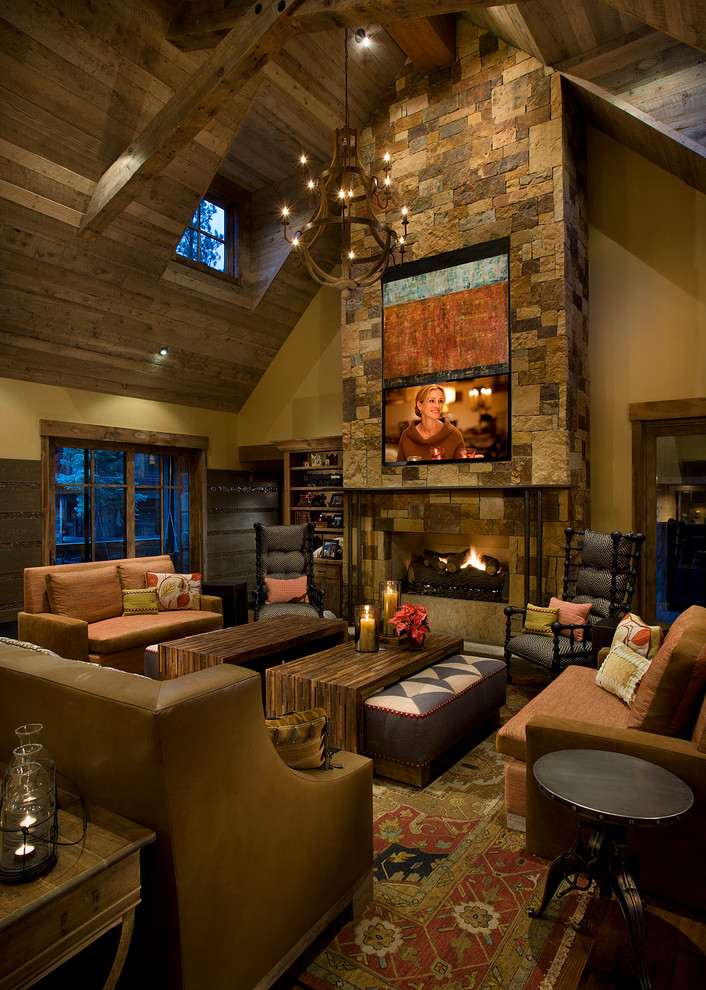 Photo of a large country enclosed living room in Sacramento with beige walls, a standard fireplace, a stone fireplace surround, a built-in media wall, medium hardwood floors and brown floor.
