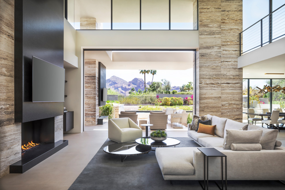 This is an example of an expansive contemporary loft-style living room in Phoenix with beige walls, a ribbon fireplace, a tile fireplace surround, a wall-mounted tv and beige floor.