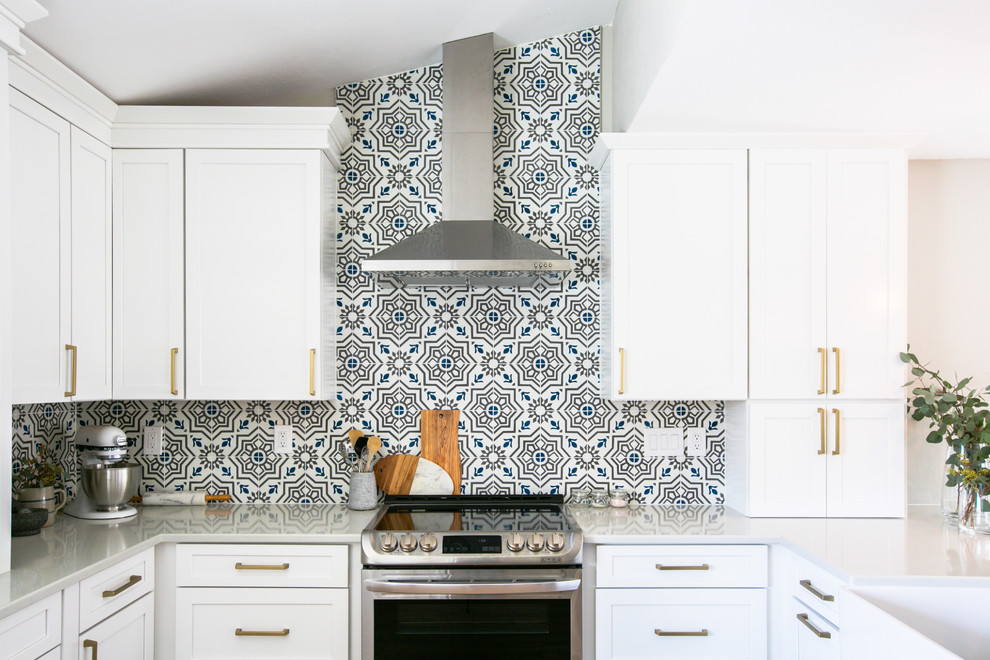 Eat-in kitchen - mid-sized transitional u-shaped vinyl floor and brown floor eat-in kitchen idea in Denver with a farmhouse sink, shaker cabinets, white cabinets, quartz countertops, multicolored backsplash, cement tile backsplash, stainless steel appliances, a peninsula and gray countertops