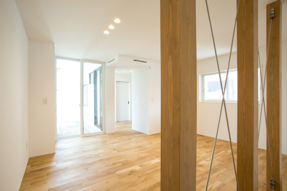 Diseño de sala de estar cerrada y blanca minimalista con paredes blancas, suelo de madera en tonos medios, suelo beige, papel pintado y papel pintado