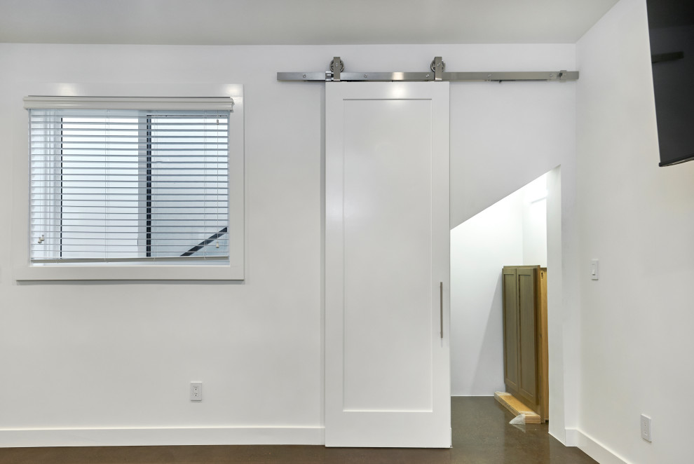 Multifunktionaler, Kleiner Uriger Fitnessraum mit weißer Wandfarbe, Betonboden und braunem Boden in San Francisco