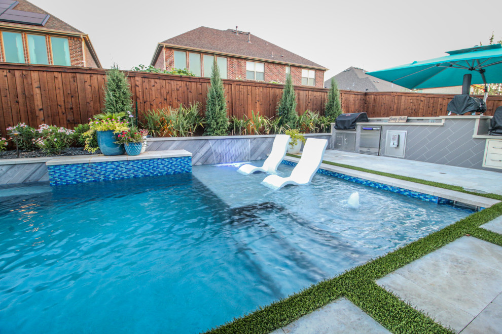 Mittelgroßer Moderner Pool hinter dem Haus in rechteckiger Form mit Wasserspiel und Natursteinplatten in Dallas