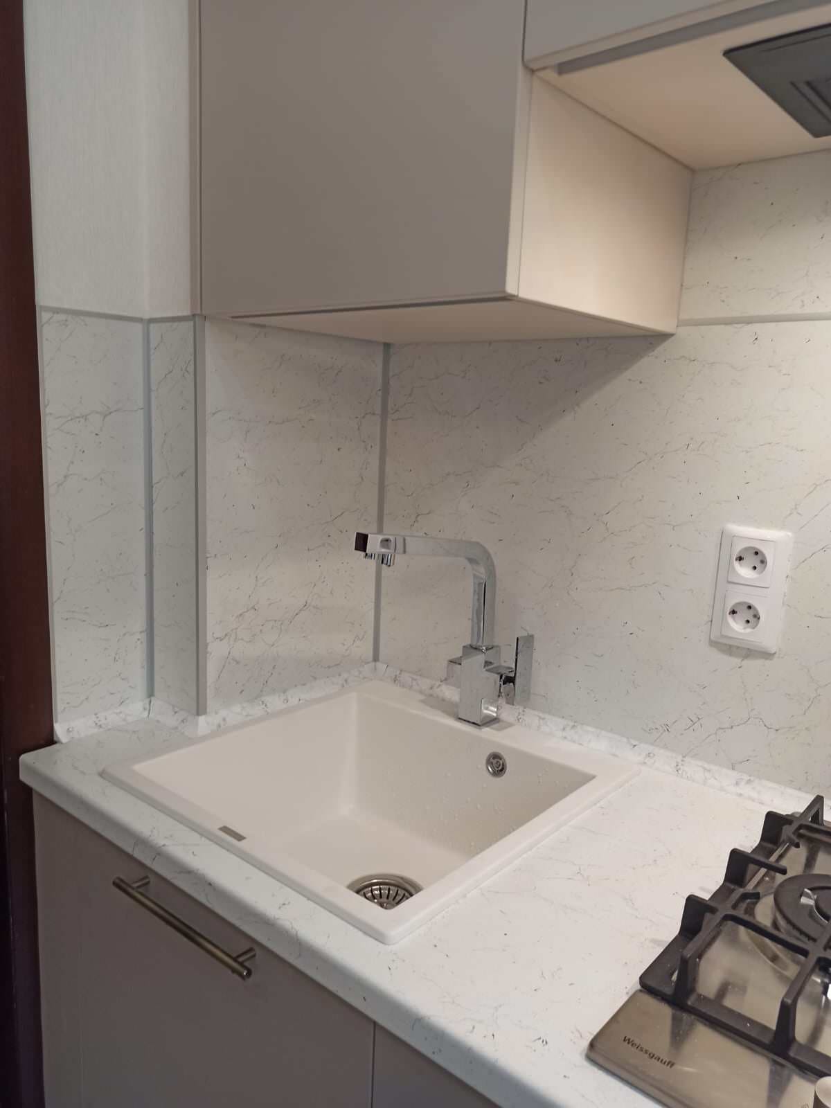 Небольшая кухня в бежевых тонах с комодом