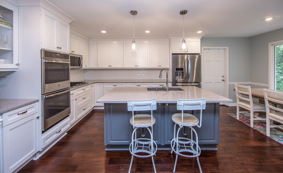 Mid-sized transitional l-shaped brown floor eat-in kitchen photo in Atlanta with an undermount sink, white cabinets, quartzite countertops, white backsplash, subway tile backsplash, stainless steel appliances, an island and gray countertops