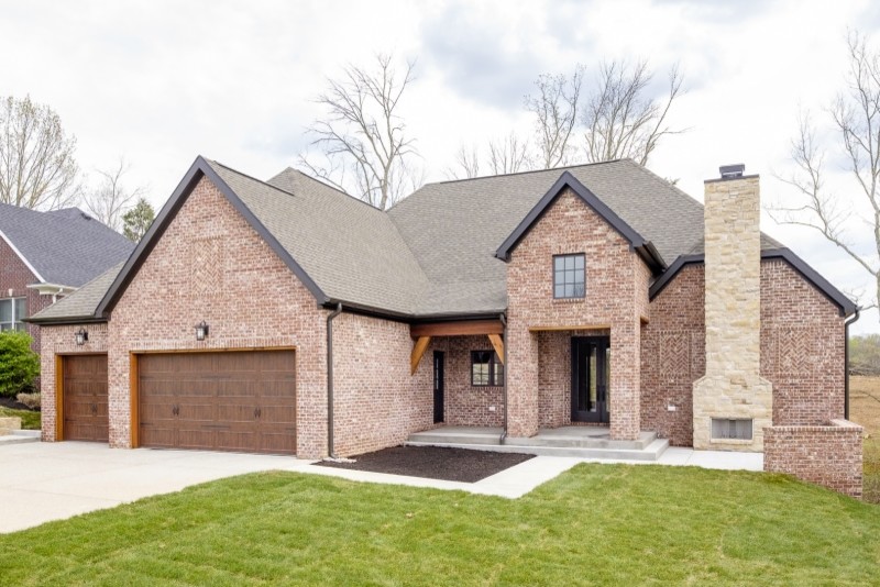 Mid-sized arts and crafts two-storey brick red exterior in Louisville with a gable roof.