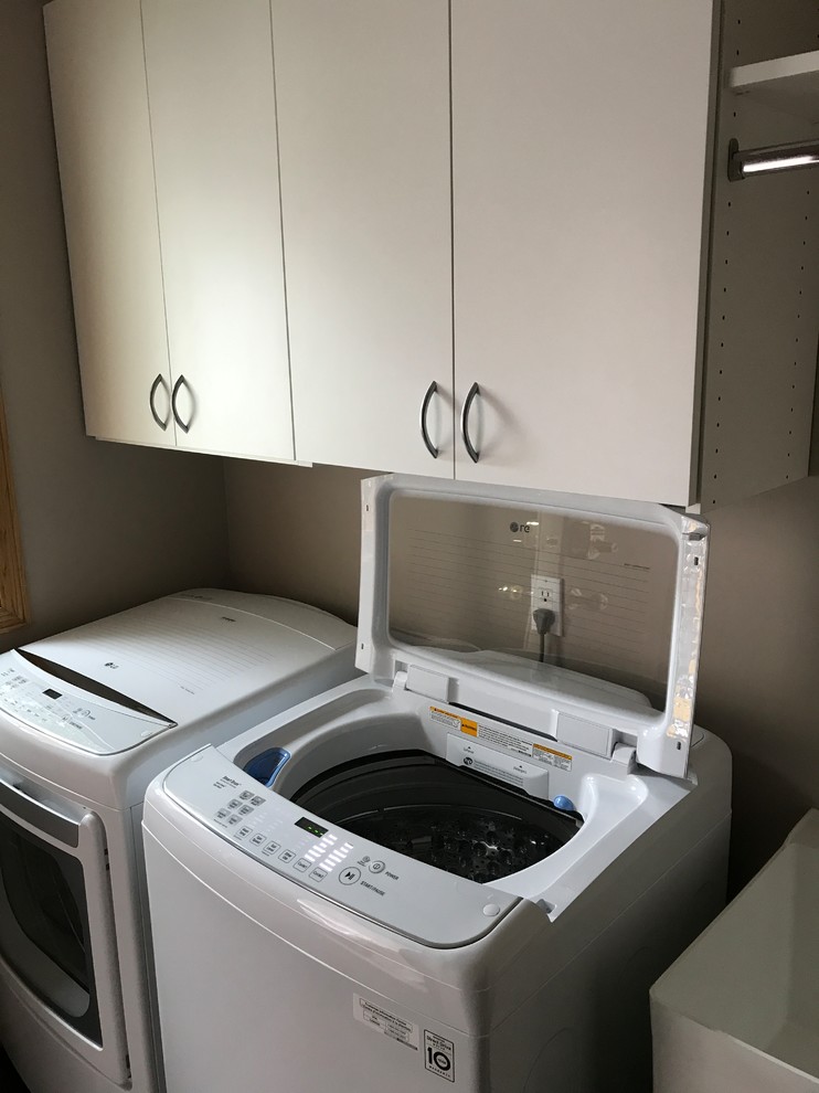 Laundry room in Minneapolis with white cabinets.