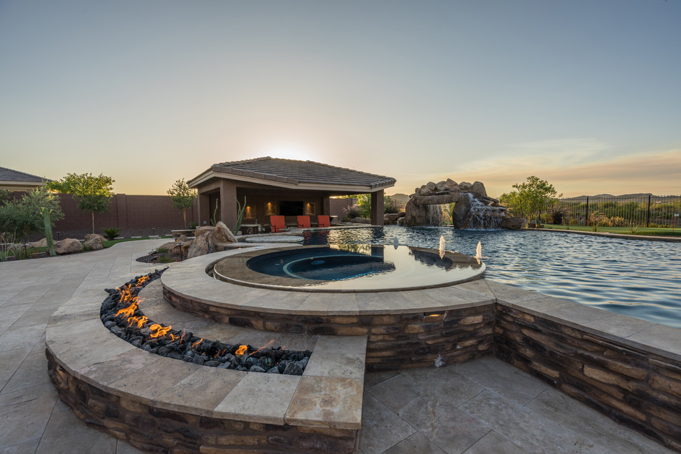 Design ideas for a large traditional backyard custom-shaped pool in Phoenix with natural stone pavers.