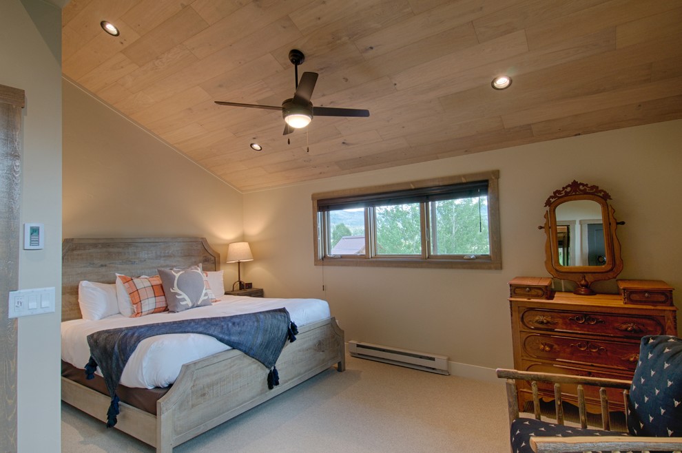 Design ideas for a mid-sized country loft-style bedroom in Denver with beige walls, carpet and beige floor.