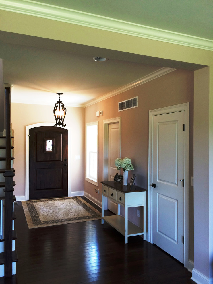 Inspiration for a mid-sized timeless dark wood floor foyer remodel in Cincinnati with beige walls and a dark wood front door
