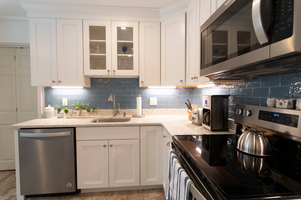 Inspiration for a mid-sized transitional u-shaped beige floor enclosed kitchen remodel in Boston with an undermount sink, recessed-panel cabinets, white cabinets, blue backsplash, subway tile backsplash, stainless steel appliances, an island and beige countertops