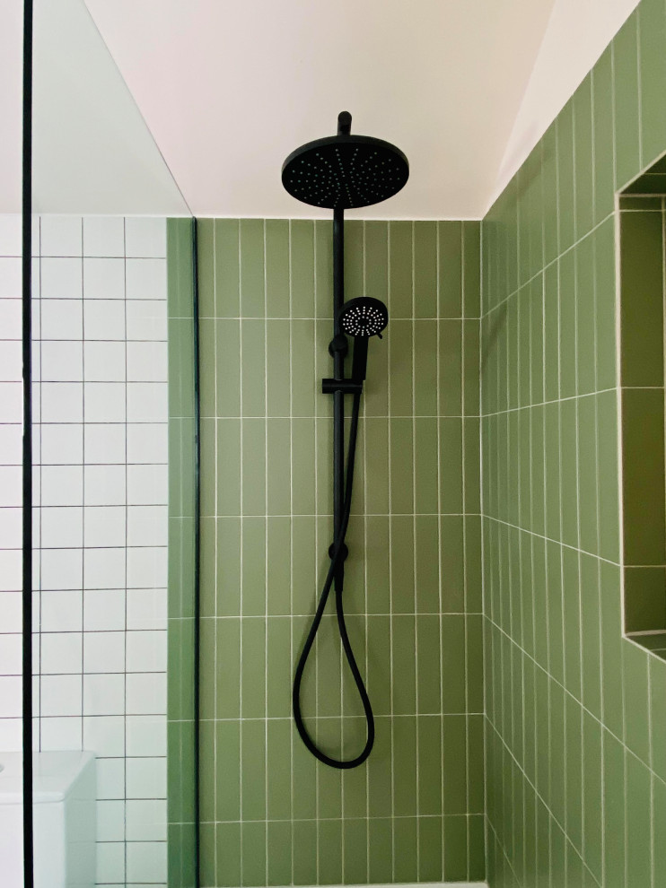 Bild på ett mellanstort funkis brun brunt en-suite badrum, med luckor med profilerade fronter, skåp i mellenmörkt trä, ett platsbyggt badkar, en dusch/badkar-kombination, en toalettstol med hel cisternkåpa, grön kakel, keramikplattor, vita väggar, klinkergolv i porslin, ett fristående handfat, träbänkskiva, grått golv och med dusch som är öppen