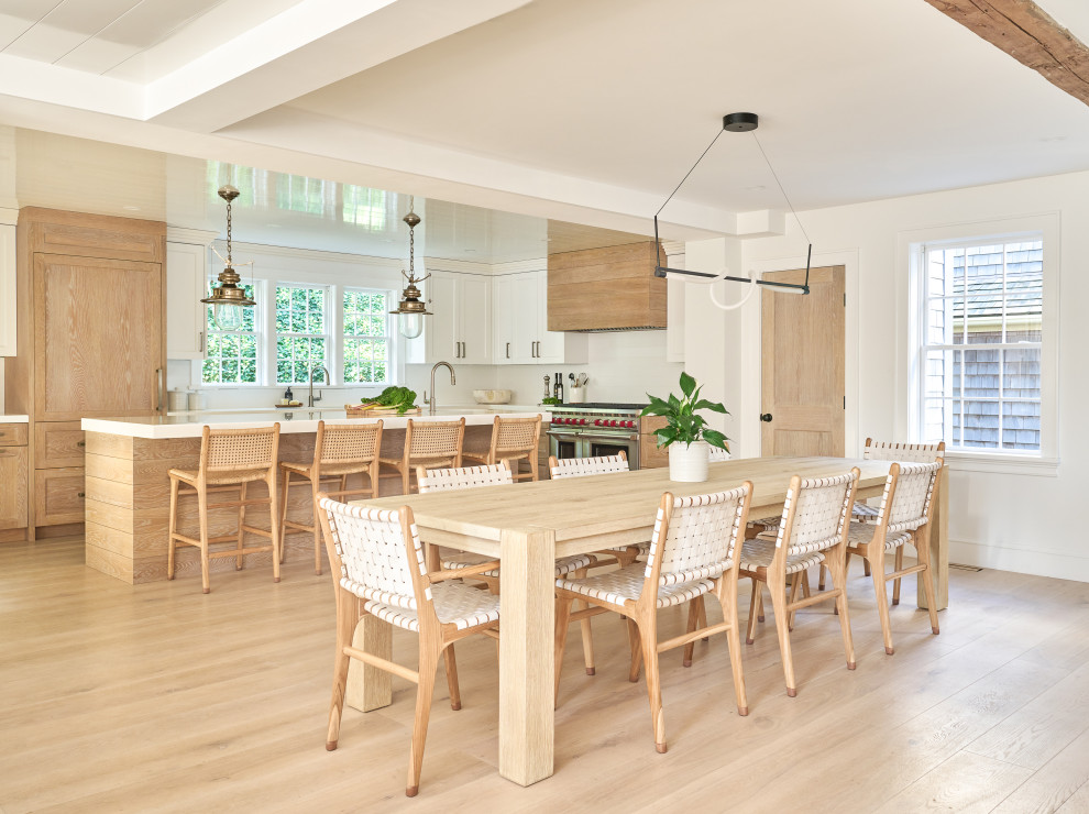 Exempel på ett maritimt vit vitt kök, med en undermonterad diskho, luckor med infälld panel, skåp i ljust trä, bänkskiva i kvarts, vitt stänkskydd, stänkskydd i keramik, integrerade vitvaror, ljust trägolv, en köksö och brunt golv