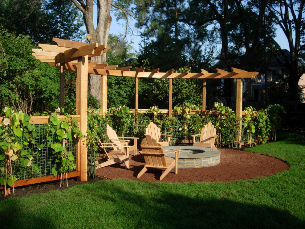 Ispirazione per un giardino chic esposto a mezz'ombra di medie dimensioni e dietro casa in estate con un focolare, graniglia di granito e recinzione in legno