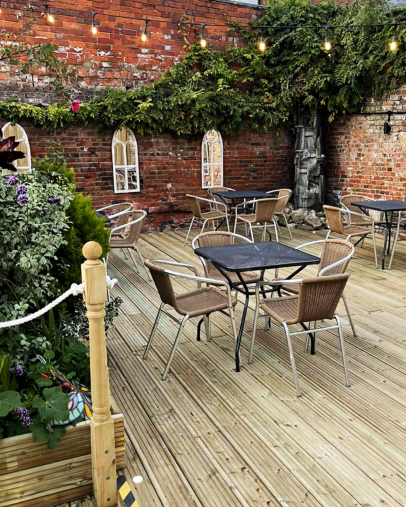 Inspiration for a traditional courtyard and ground level deck in Dorset with no cover and wood railing.