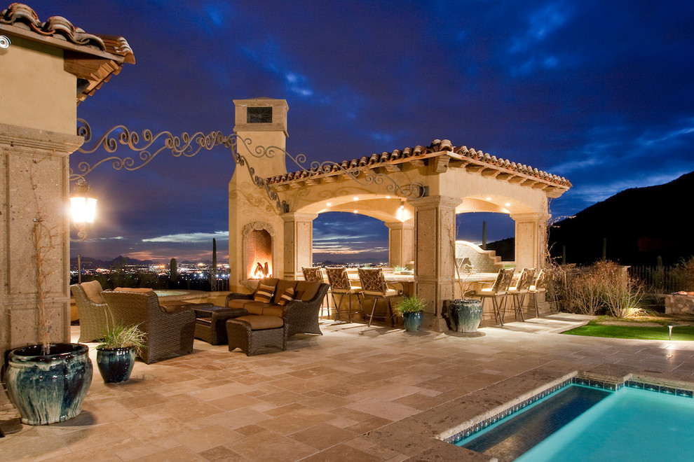 Photo of an expansive mediterranean backyard patio in Phoenix with a fire feature and natural stone pavers.