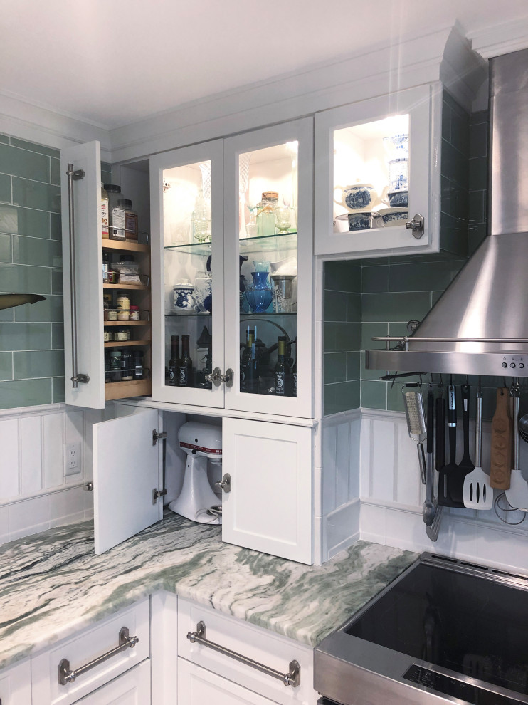 Inspiration for a mid-sized transitional u-shaped light wood floor and white floor kitchen remodel with glass-front cabinets, white cabinets, marble countertops, green backsplash, glass tile backsplash, stainless steel appliances and green countertops