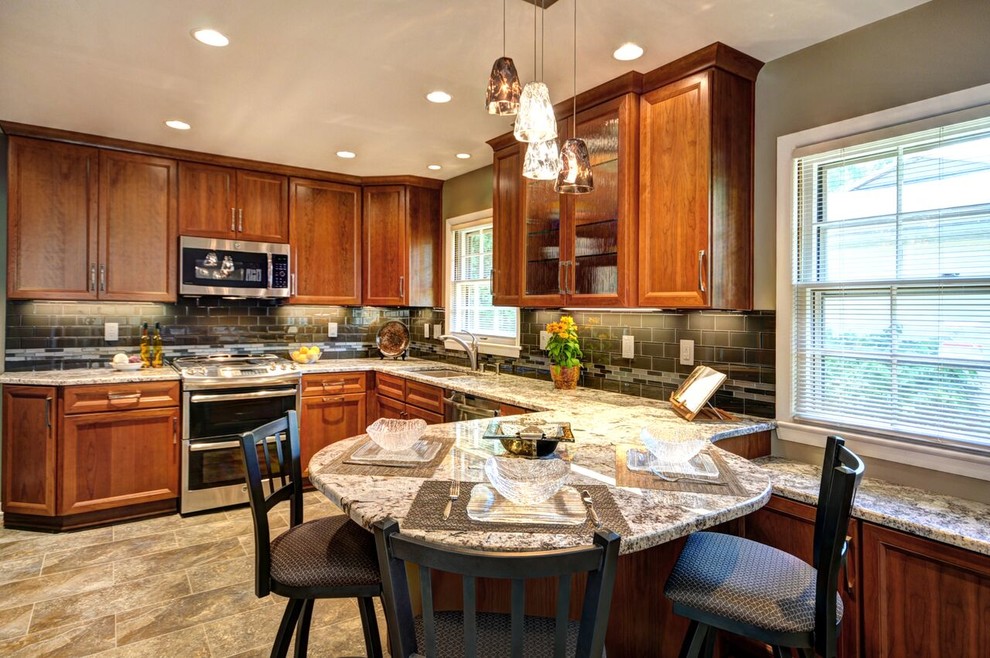 Example of a mid-sized transitional l-shaped vinyl floor enclosed kitchen design in Milwaukee with an undermount sink, raised-panel cabinets, medium tone wood cabinets, granite countertops, gray backsplash, glass tile backsplash and stainless steel appliances