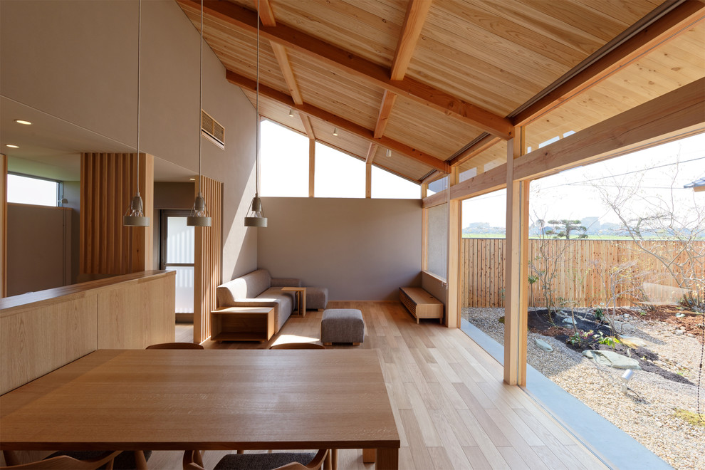 This is an example of a mid-sized asian living room in Kyoto with grey walls, light hardwood floors and beige floor.