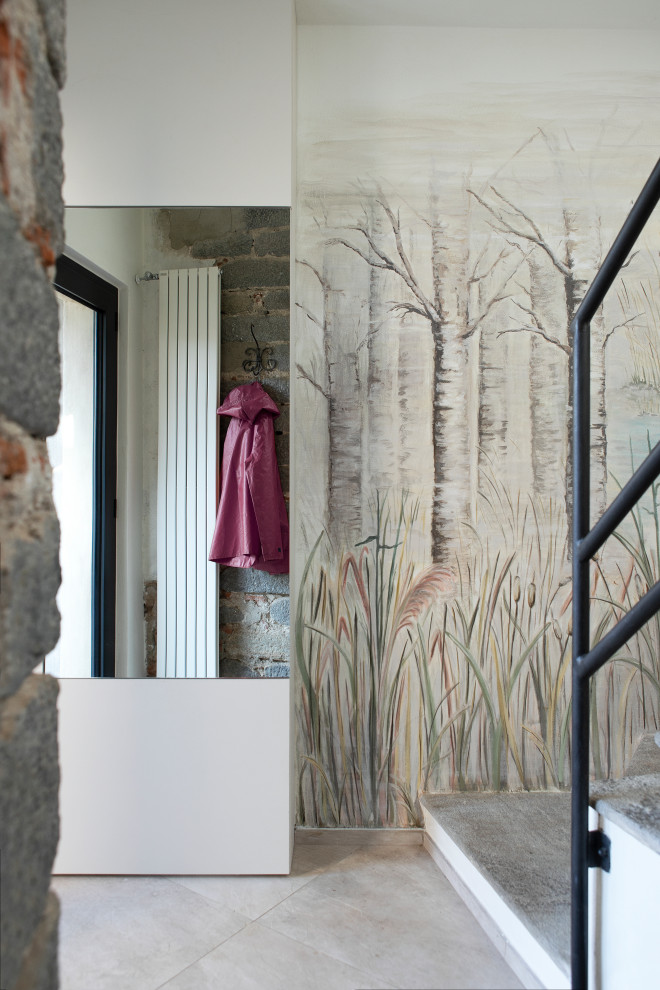 Photo of a large country foyer in Turin with multi-coloured walls, porcelain floors, a pivot front door, a glass front door, beige floor and wallpaper.