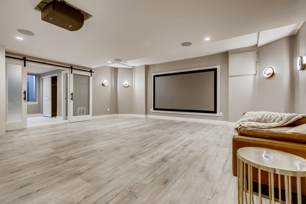 Large modern enclosed home theatre in Denver with grey walls, vinyl floors, a projector screen and grey floor.