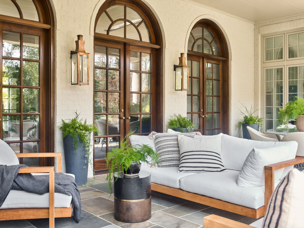 Foto de patio clásico grande en patio trasero y anexo de casas con adoquines de piedra natural