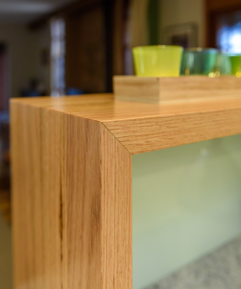 Inspiration for a mid-sized modern u-shaped open plan kitchen in Melbourne with a drop-in sink, flat-panel cabinets, light wood cabinets, laminate benchtops, blue splashback, glass tile splashback, black appliances, slate floors and a peninsula.