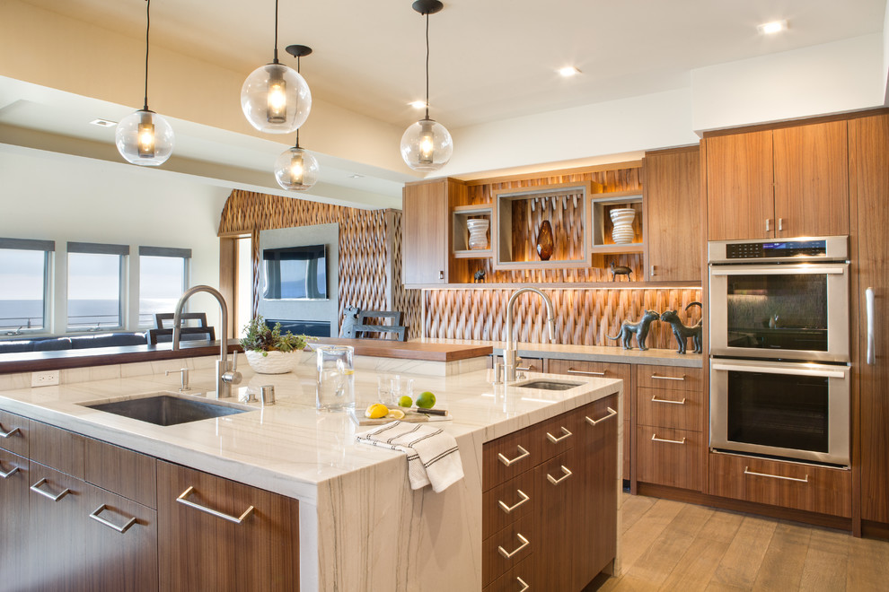Mid-sized eat-in kitchen in Orange County with an undermount sink, flat-panel cabinets, medium wood cabinets, marble benchtops, panelled appliances, medium hardwood floors and with island.