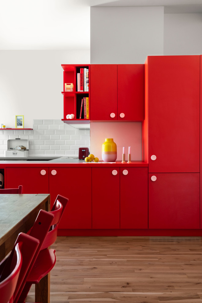ベルリンにあるお手頃価格の中くらいなモダンスタイルのおしゃれなキッチン (フラットパネル扉のキャビネット、赤いキャビネット、赤いキッチンカウンター) の写真