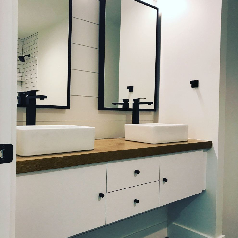 Mid-sized modern master bathroom in Philadelphia with flat-panel cabinets, white cabinets, white walls, a trough sink, wood benchtops, brown benchtops, a double vanity and a floating vanity.