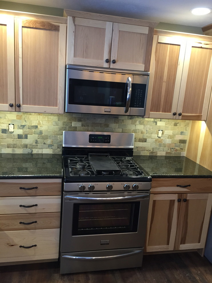 Example of a large mountain style l-shaped dark wood floor eat-in kitchen design with a double-bowl sink, flat-panel cabinets, light wood cabinets, granite countertops, brown backsplash, stone tile backsplash, stainless steel appliances and an island