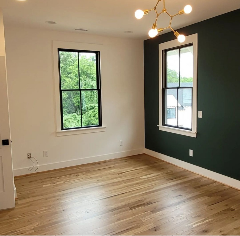 Imagen de habitación de invitados costera de tamaño medio sin chimenea con paredes verdes y suelo de madera clara