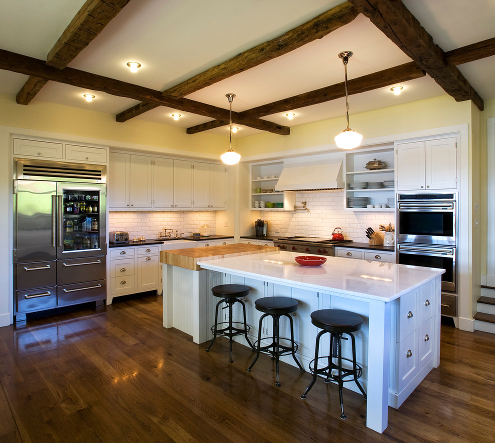 Inspiration for a traditional kitchen in Boston with a farmhouse sink, stainless steel appliances and white cabinets.
