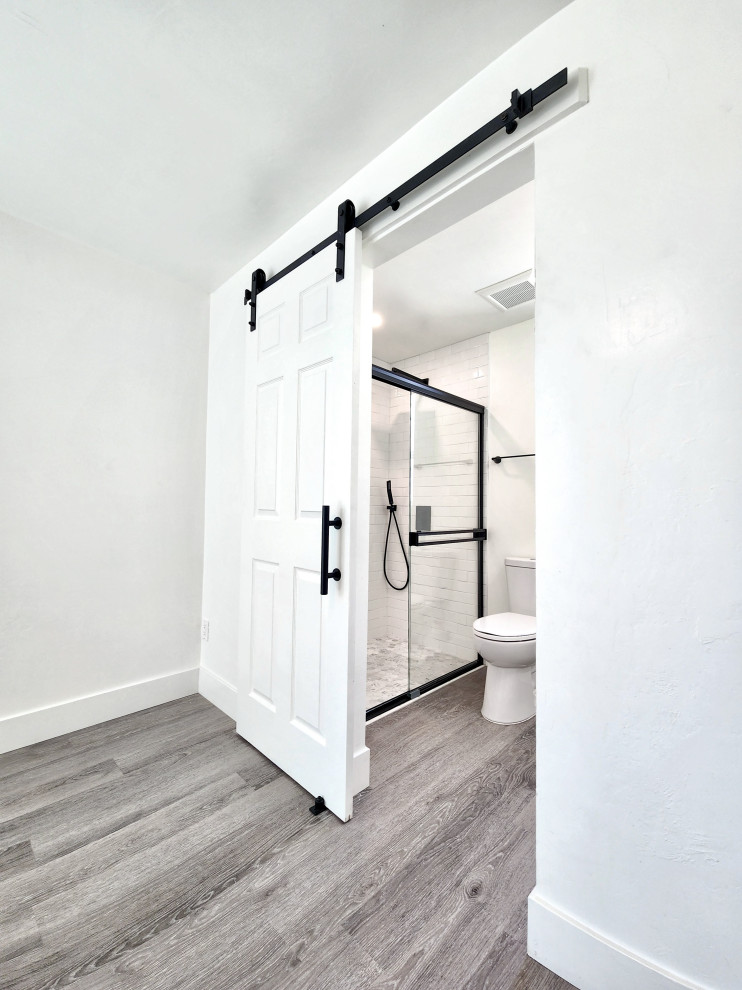 This is an example of a small scandi shower room bathroom in Phoenix with beaded cabinets, white cabinets, a built-in bath, a walk-in shower, a one-piece toilet, white tiles, ceramic tiles, white walls, vinyl flooring, a built-in sink, marble worktops, beige floors, an open shower, white worktops, an enclosed toilet, a single sink, a floating vanity unit and a vaulted ceiling.