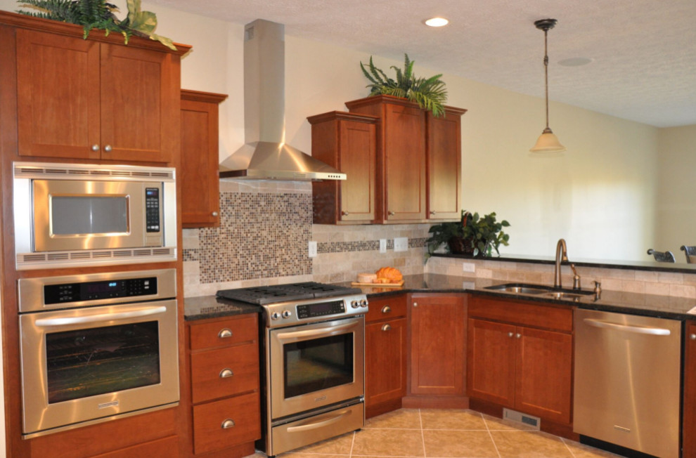 Inspiration for a mid-sized timeless l-shaped porcelain tile and beige floor open concept kitchen remodel with a double-bowl sink, shaker cabinets, brown cabinets, granite countertops, beige backsplash, porcelain backsplash and stainless steel appliances