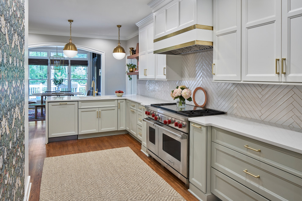 シャーロットにある高級な中くらいなトランジショナルスタイルのおしゃれなキッチン (アンダーカウンターシンク、落し込みパネル扉のキャビネット、緑のキャビネット、クオーツストーンカウンター、白いキッチンパネル、セラミックタイルのキッチンパネル、シルバーの調理設備、無垢フローリング、茶色い床、白いキッチンカウンター) の写真