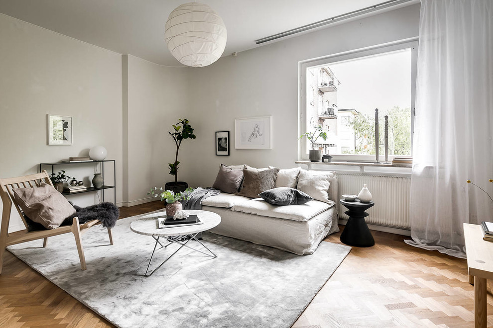 Design ideas for a mid-sized scandinavian formal enclosed living room in Stockholm with white walls, beige floor and light hardwood floors.